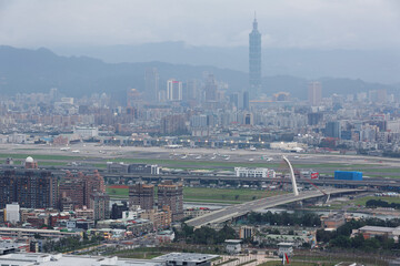 Fototapeta premium Panoramic aerial view of busy Taipei city, Keelung river, Dazhi Bridge, Songshan Airport and Taipei 101 at dusk ~ A romantic evening in Taipei Taiwan, with beautiful blue gloomy mood in the sky