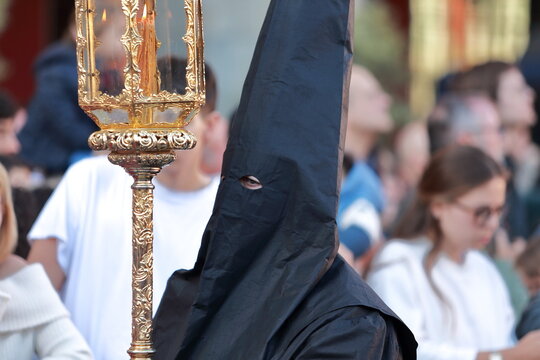 Black-hooded Nazareno with processional lantern during Holy Week in Madrid, Spain