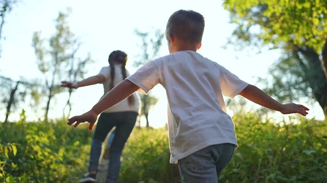 Group of children running through forest. Happy kids play and run along lush forest path. Joyful outdoor adventure as children explore and play. Group of children running in forest, enjoying nature.