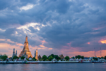 Naklejka premium Majestic sunset over Wat Arun (Temple of Dawn) along the Chao Phraya River, Bangkok, Thailand