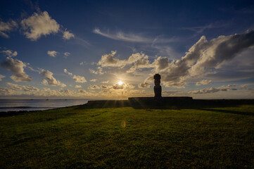 Fototapeta premium Majestic ancient moai statue stands tall on beautiful rapa nui easter island radiating peaceful energy during vibrant sunset over vast ocean creating stunning dark silhouette against cloudy sky