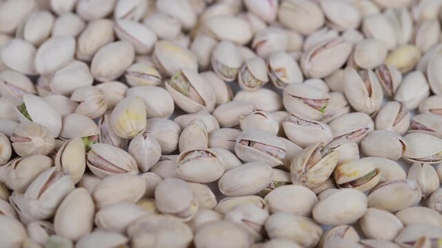 Closeup of salted pistachio shells with natural lighting and texture. Highresolution image showcasing densely packed salted pistachio shells with natural light and market appeal
