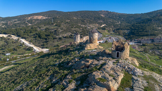 Aerial High Angle View of Ancient Stone Windmills on Hill with Old Foca Town and Aegean Sea in Izmir Turkey