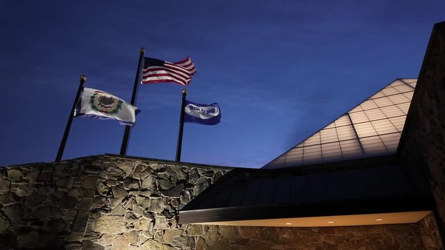 Closeup View of West Virginia Flags Flying at Night Atop Building