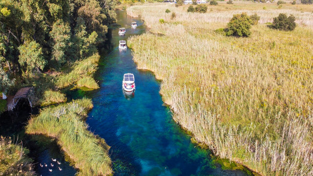 Aerial Top Down View of Crystal Clear Azmak River with Tour Boats and Reeds in Akyaka Turkey