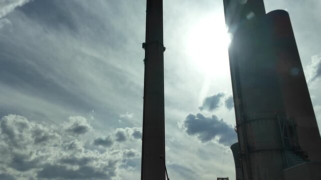 Driving Past Smokestacks on a Cloudy Day With Sun Behind