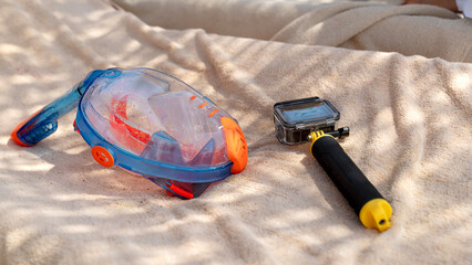 Sunlit beach holds snorkel gear and camera © I