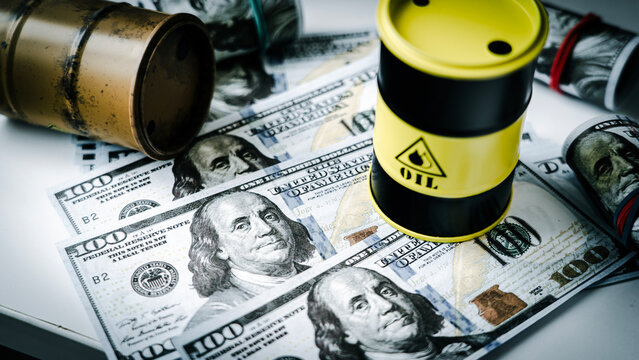 Oil drums rest atop crisp dollar bills