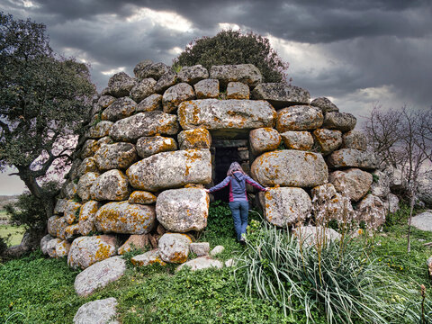 Donna entra in un nuraghe della Sardegna