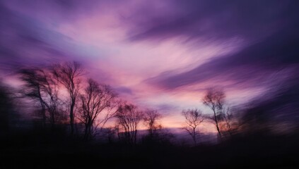 Obraz premium Dramatic Purple Sunset Sky Over Silhouetted Trees.