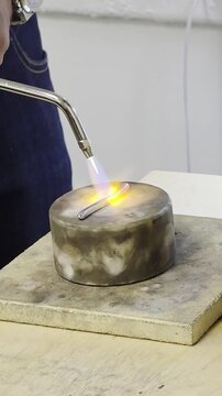 jeweler melts the metal