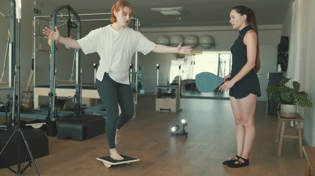 Woman balancing on a board during a physiotherapy session