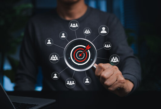 Targeting and Customer Selection Concept. Person holding magnifying glass over target with user icons representing customer segmentation, audience analysis, market targeting, focused outreach, loyalty