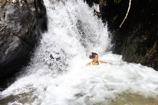 Women relaxing in a natural river stream in the lush South American tropical forest