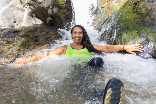 Women relaxing in a natural river stream in the lush South American tropical forest