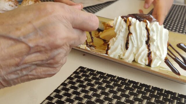 Elderly woman and child eating whipped cream dessert