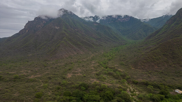 Aerial view of La Leche River winding through green valley with rice fields and mountains in Lambayeque Peru