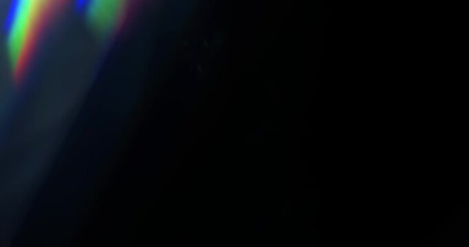 Real rainbow of light leaks through prism in a seamless loop. Lens flares through glass in vibrant chromatic aberration colours. Optical effect of shining light rays in a brilliant spectrum of colors