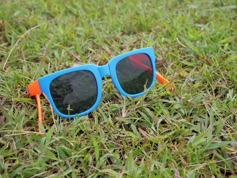 Eye level view of blue sunglasses on green grass