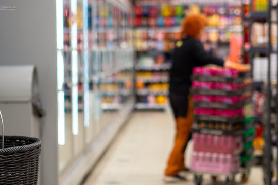 Female Shopper Browsing Colorful Shelves in Supermarket Defocused
