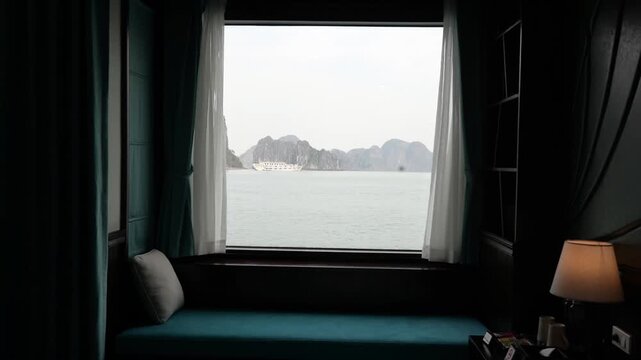Window view of Ha Long Bay from cozy hotel room interior