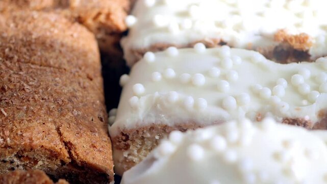 Close-up cinematic shot of delicious homemade cookies with white frosting and sprinkles.