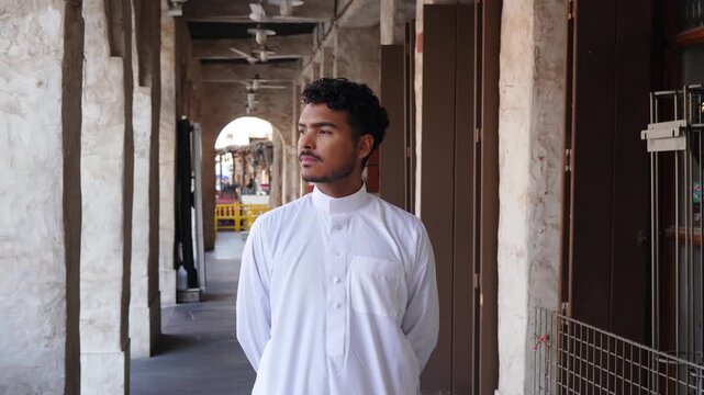 Portrait of Arab man in traditional clothing in historic corridor