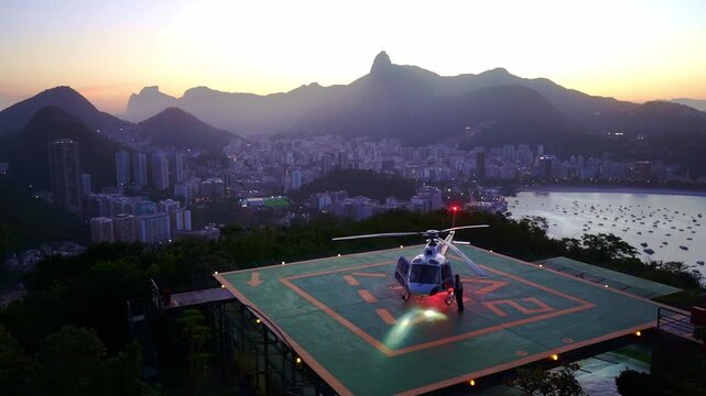 Luxury helicopter on rooftop with Rio skyline and mountains