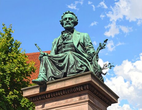 A bronze statue of a seated man with a book