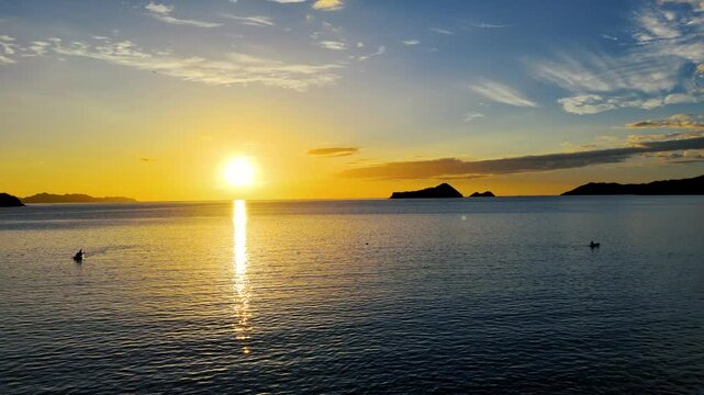 oma a&eacute;rea cinematogr&aacute;fica de drone de kayakeros remando en el oc&eacute;ano Pac&iacute;fico al atardecer, costa dorada de Costa Rica.