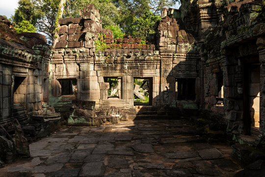 Ancient stone ruins stand silent under dappled sunlight, Preah Khan, Angkor, Cambodia