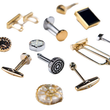 Assortment of varied metal cufflink designs, close-up, against a stark black background