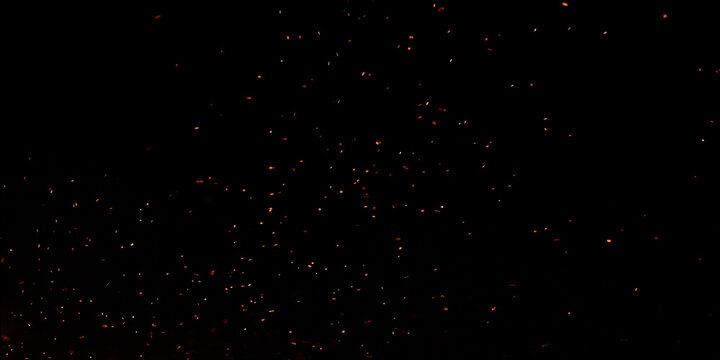 Blur, bokeh, fire, red light, tiny specks created by the heat energy of burning fuel on a black background.