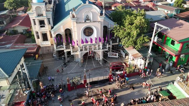 Aerial drone footage of Filipino SinaKulo Pinetensya during Holy Week in front of a parish church, highlighting powerful religious devotion and cultural heritage. Captures dramatic passion play