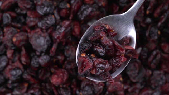 Macro top-down view of a spoon scooping a pile of dried cranberries
