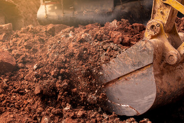 Closeup bucket of backhoe digging the soil at construction site. Crawler excavator digging on demolition site. Excavating machine. Earth moving equipment. Excavation vehicle. Construction business. © Fahroni