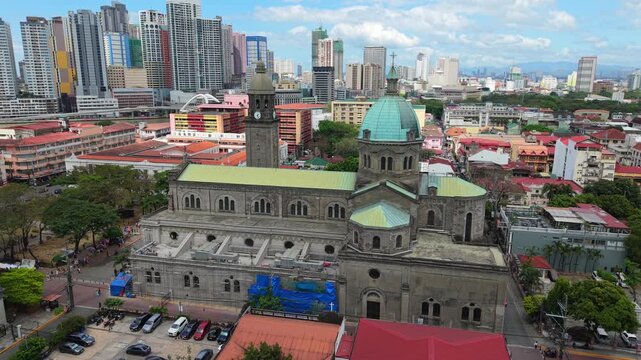 Aerial drone view of Manila Cathedral in Intramuros with modern skyline in the background. Iconic historic landmark in the heart of Manila, Philippines.