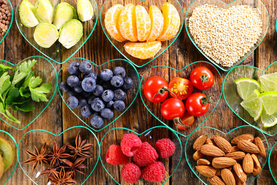Heart healthy food concept with superfoods in heart shaped bowls on wooden background