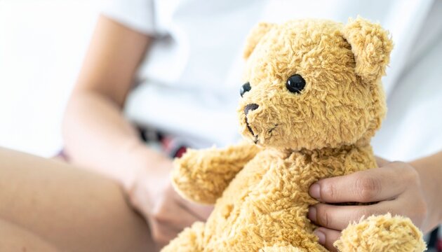 すわりながらクマのぬいぐるみを抱える女性の写真