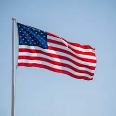 Fototapeta premium American flag waving on a pole against a clear blue sky