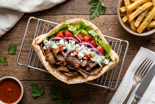 Top down view of a gourmet doner kebab sandwich with french fries