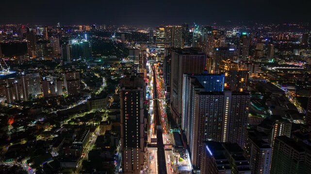Aerial night timelapse of Manila, Philippines, showing busy city traffic, glowing skyscrapers, and urban skyline lights in a modern Southeast Asian metropolis.