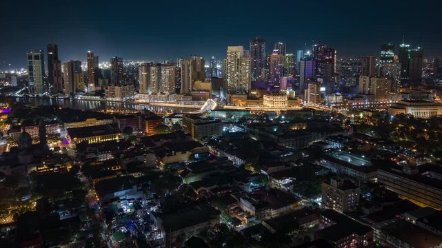 Aerial night timelapse of Manila skyline in the Philippines, featuring illuminated skyscrapers, glowing city lights, and modern urban architecture in a vibrant Southeast Asian metropolis.