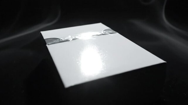 Luxurious white gift box sealed with tape against a dark backdrop surrounded by elegant smoke