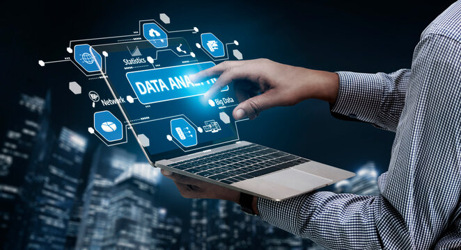 A close-up view of a hand interacting with a laptop, displaying digital graphics related to data analysis amid a vibrant cityscape. Ideal for technology and business themes. Tessel