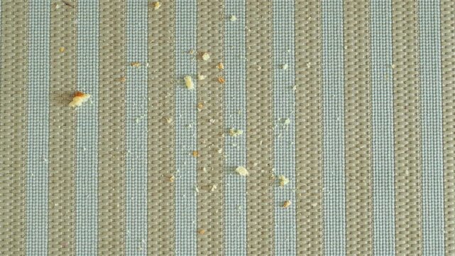 Crumbs left on a blue tablecloth after a snack