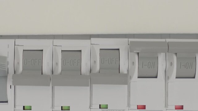 Hand switching circuit breaker in electrical distribution panel. Concept of power control electrical safety household utility and energy management.