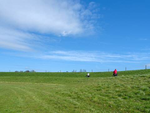 Cyclists on the dike along the river IJssel - Fietsers op de dijk langs de rivier de IJssel