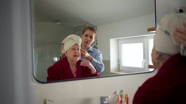 Daughter helping mom to wash her hair. Mother's Day concept.