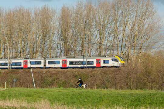 31 March 2026, Eppegem, Belgium. Belgian NMBS train with cyclist in foreground